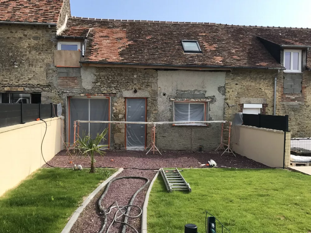 Maison ancienne en pierre avec toiture de tuiles, jardin en cours d'aménagement