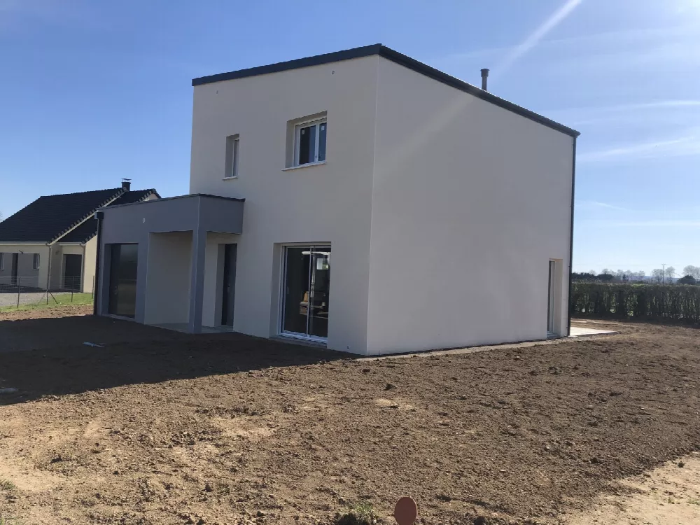 Maison contemporaine à toit plat et façade blanche, terrain en cours d'aménagement
