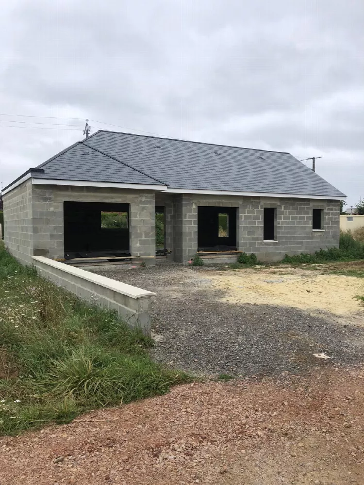 Maison en cours de construction, murs en parpaings et toit d'ardoises