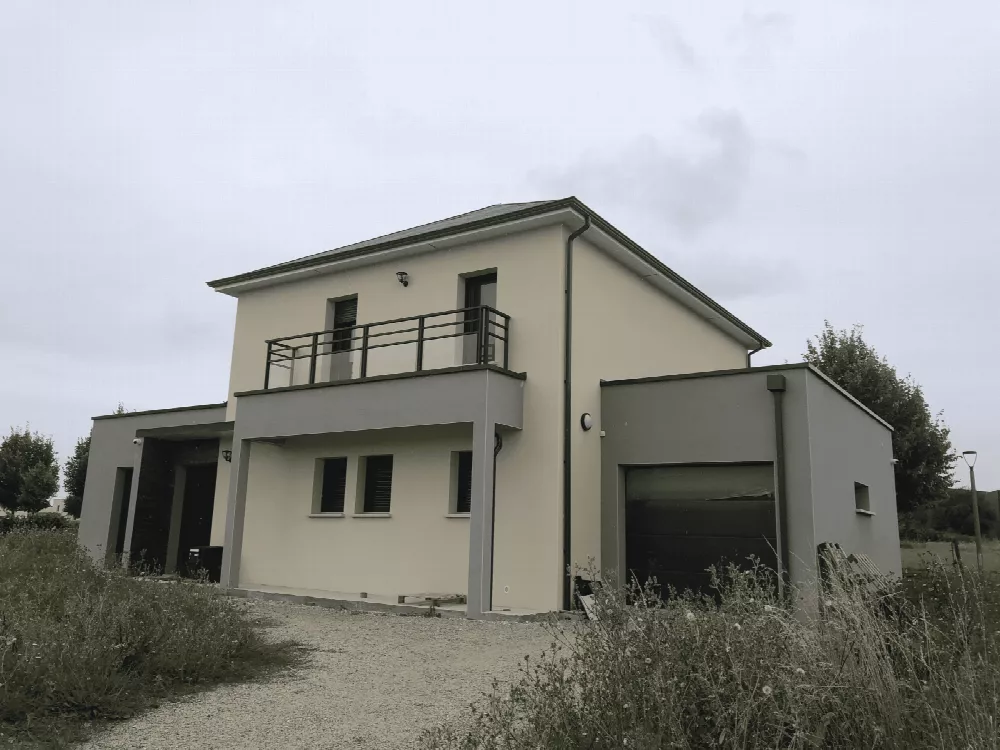 Maison à étage avec balcon à garde-corps noir et garage