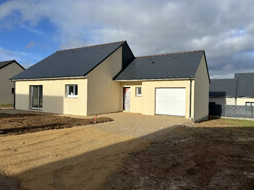 Maison neuve à deux volumes, toit d'ardoises et porte de garage blanche