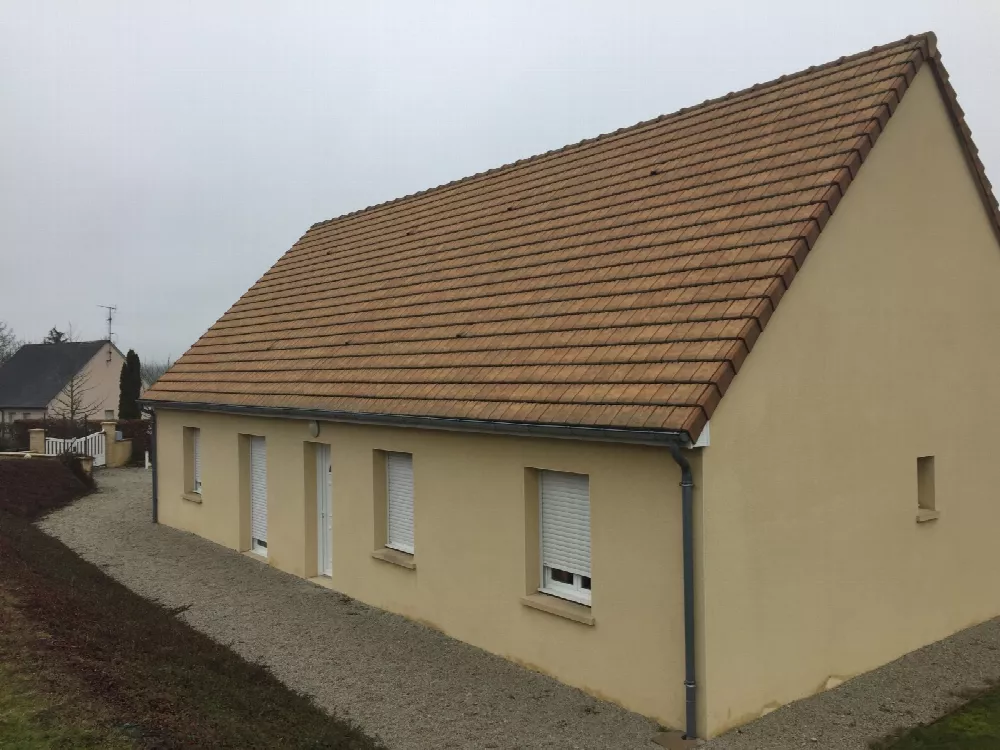 Maison de plain-pied à façade jaune pâle et toiture de tuiles brunes