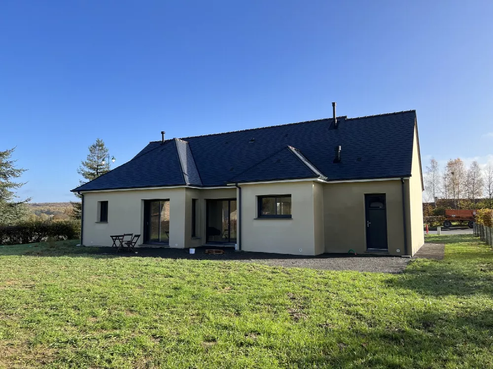 Maison de plain-pied à toit d'ardoises vue de l'arrière, pelouse engazonnée