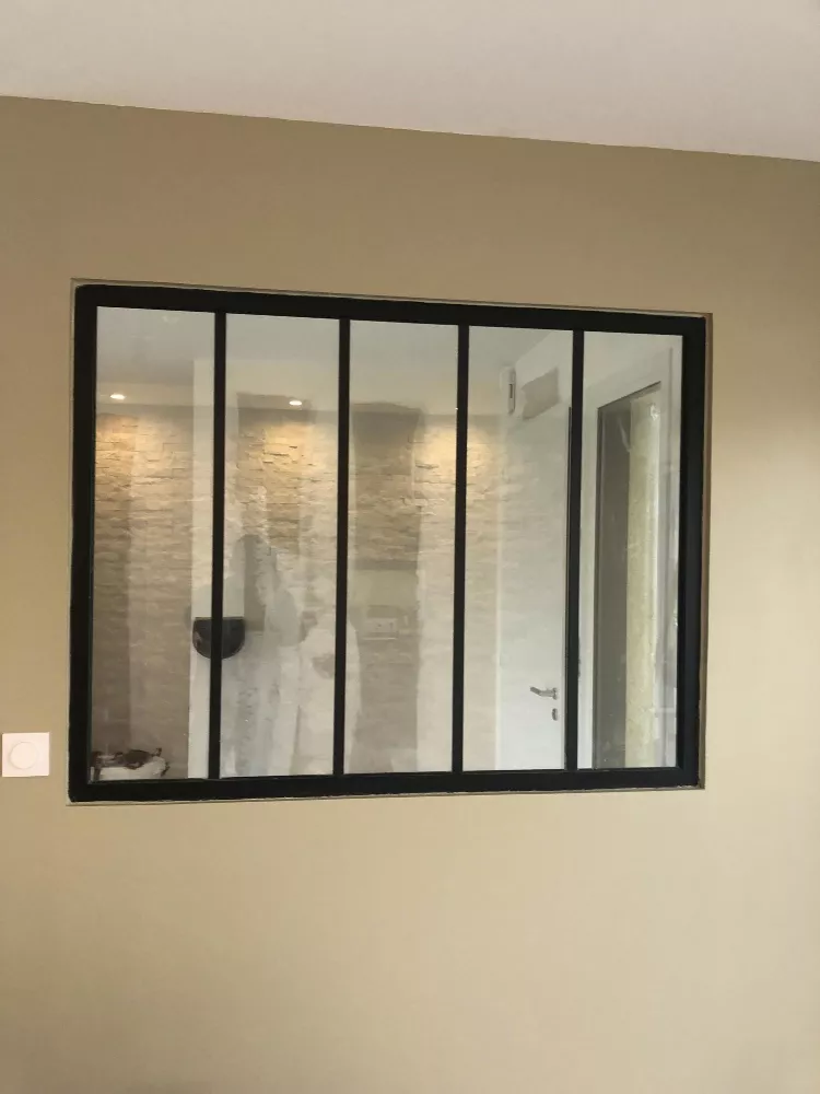 Verrière d'atelier à cadre noir dans une cloison intérieure